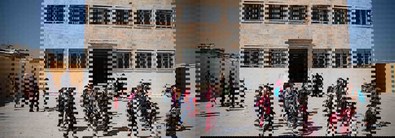 Children walking past a school in Syria