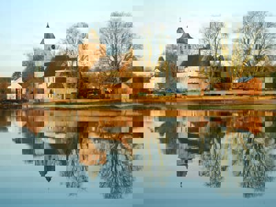 Old church of Oosterbeek, a Battle of Arnhem monument, reflected in the River Rhine